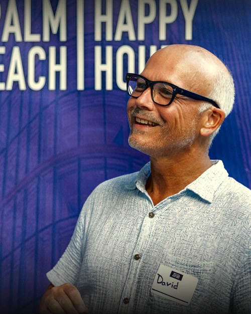 A guest in front of the West Palm Beach Tech Happy Hour backdrop